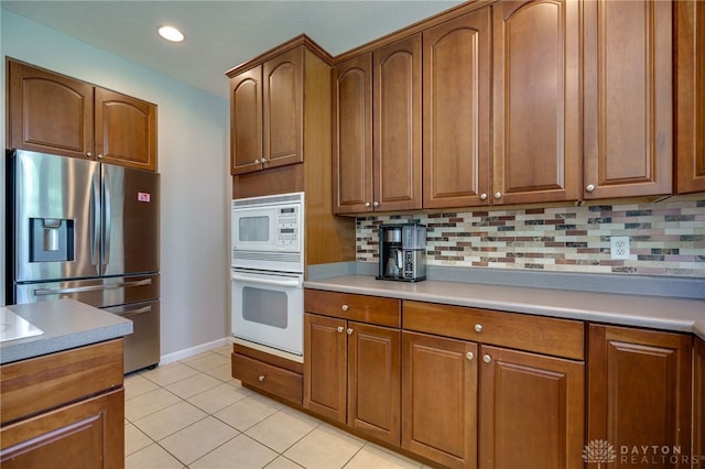 3334 Greycliff Trl, Franklin Twp, OH 45005 - kitchen featuring white appliances, backsplash, brown cabinetry, light countertops, and light tile patterned floors