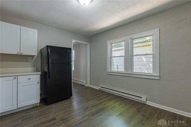 50 N Main St, Franklin, OH 45005 - kitchen with freestanding refrigerator, a baseboard heating unit, dark wood-style flooring, and white cabinets