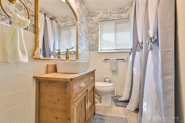 4108 Central Ave, Middletown, OH 45044 - bathroom featuring wallpapered walls, tile walls, vanity, and a wainscoted wall