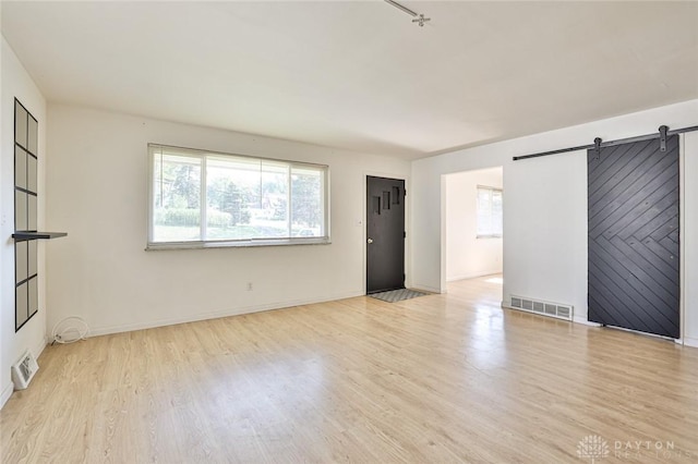 4108 Central Ave, Middletown, OH 45044 - spare room featuring a barn door, wood finished floors, and healthy amount of natural light