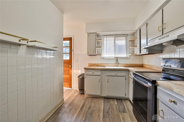 4108 Central Ave, Middletown, OH 45044 - kitchen with stainless steel electric range oven, under cabinet range hood, open shelves, tile walls, and light countertops