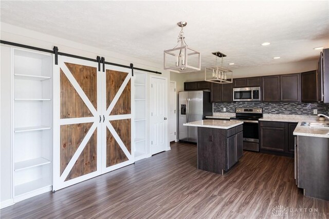 133 Followers Way, Waynesville, OH 45068 - kitchen featuring stainless steel appliances, a barn door, dark brown cabinets, light countertops, and recessed lighting
