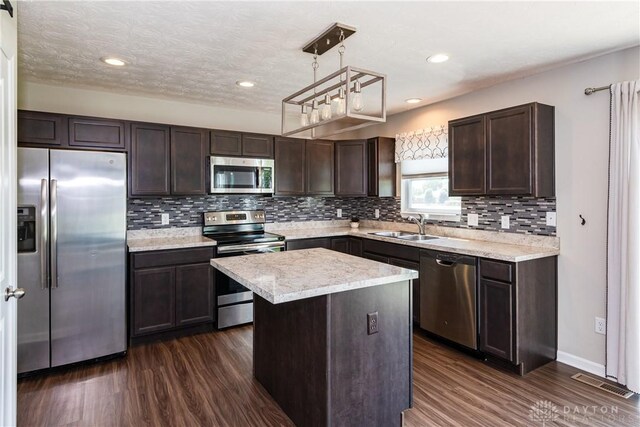 133 Followers Way, Waynesville, OH 45068 - kitchen with stainless steel appliances, dark brown cabinets, dark wood-type flooring, tasteful backsplash, and a center island
