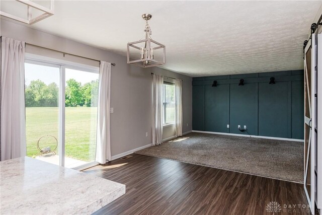 133 Followers Way, Waynesville, OH 45068 - unfurnished dining area featuring a chandelier, a barn door, and dark wood finished floors