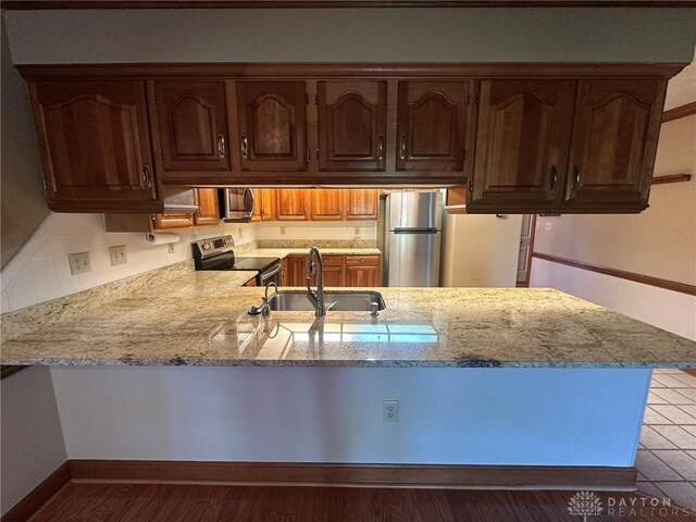 6553 Stillcrest Way, Dayton, OH 45414 - kitchen featuring stainless steel appliances, a peninsula, light stone counters, and backsplash