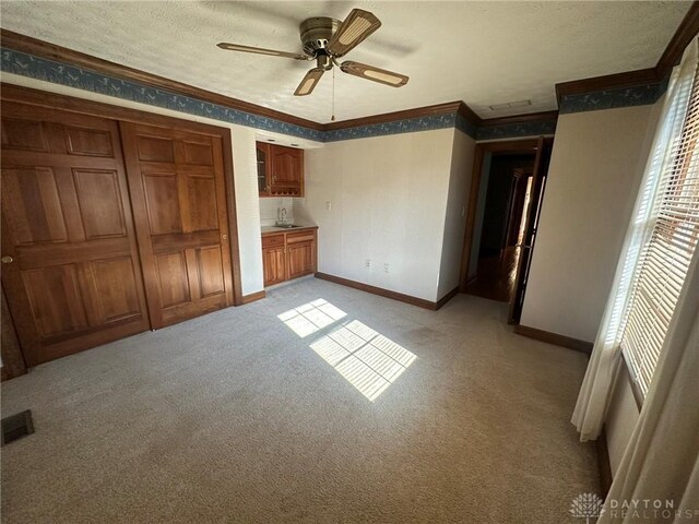 6553 Stillcrest Way, Dayton, OH 45414 - unfurnished bedroom featuring crown molding, light colored carpet, a textured ceiling, and a ceiling fan