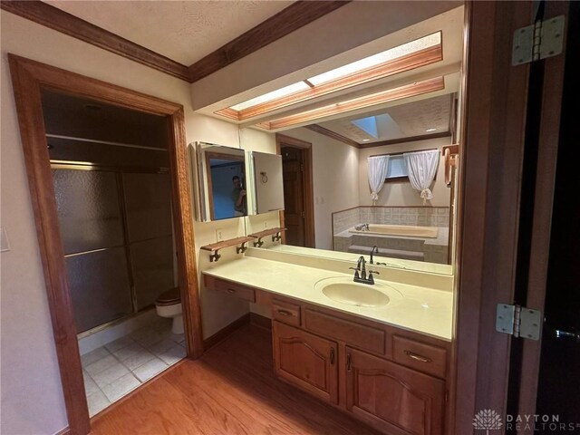 6553 Stillcrest Way, Dayton, OH 45414 - bathroom featuring ornamental molding, a stall shower, vanity, and wood finished floors