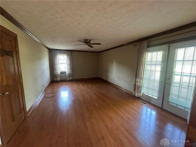 6553 Stillcrest Way, Dayton, OH 45414 - empty room featuring a textured ceiling, a ceiling fan, ornamental molding, and wood finished floors