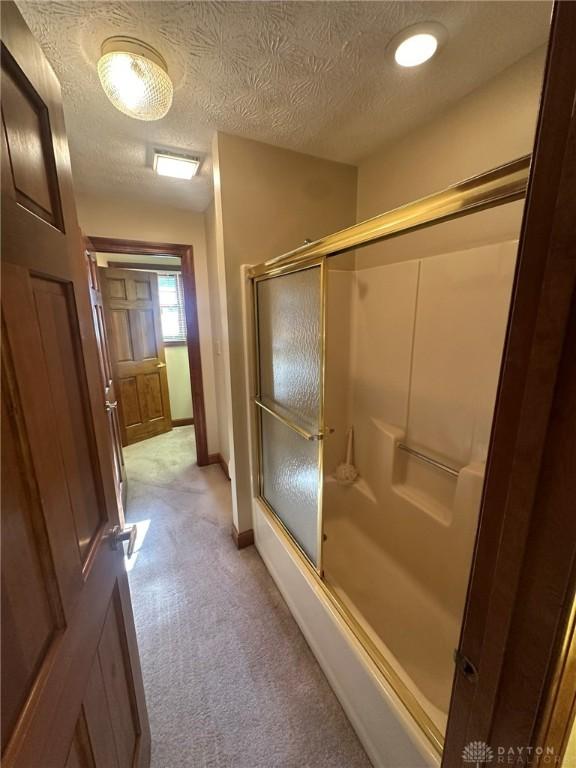6553 Stillcrest Way, Dayton, OH 45414 - bathroom with a shower with door and a textured ceiling