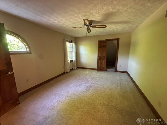 6553 Stillcrest Way, Dayton, OH 45414 - unfurnished bedroom with multiple windows, light colored carpet, a textured ceiling, and a ceiling fan