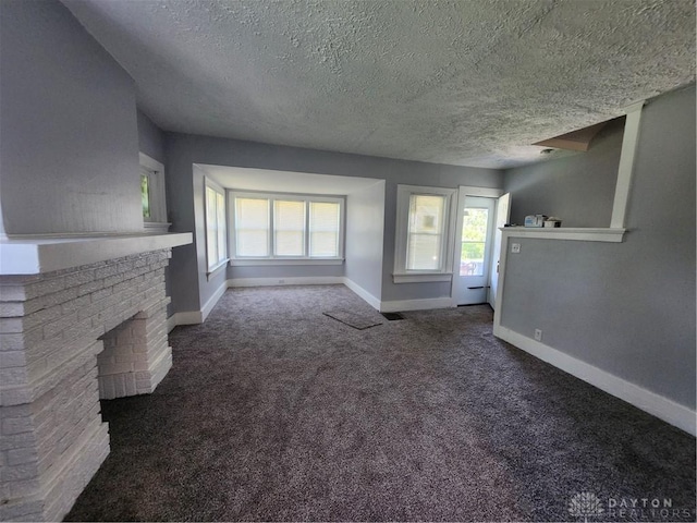 953 Five Oaks Ave Unit 943, Dayton, OH 45406 - unfurnished living room with a textured ceiling, carpet flooring, and a brick fireplace