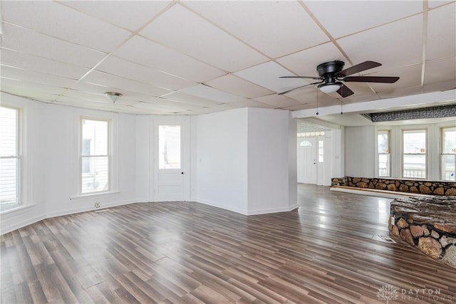 2241 E 3rd St, Dayton, OH 45403 - unfurnished living room featuring a paneled ceiling, ceiling fan, wood finished floors, and plenty of natural light