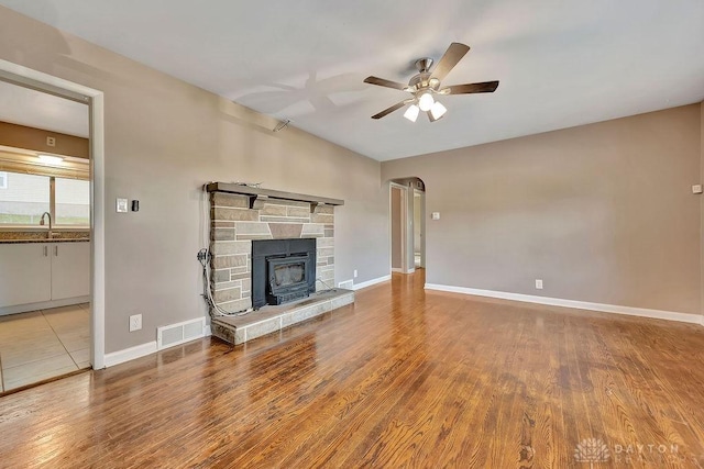 1210 Clovernook Dr, Hamilton, OH 45013 - unfurnished living room with a ceiling fan, wood finished floors, and a stone fireplace