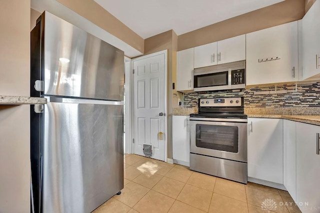 1210 Clovernook Dr, Hamilton, OH 45013 - kitchen featuring appliances with stainless steel finishes, tasteful backsplash, light tile patterned floors, and white cabinetry
