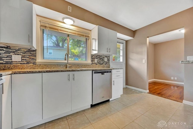 1210 Clovernook Dr, Hamilton, OH 45013 - kitchen featuring dishwasher, backsplash, light stone counters, light tile patterned floors, and white cabinets