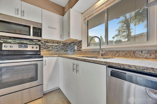 1210 Clovernook Dr, Hamilton, OH 45013 - kitchen with appliances with stainless steel finishes, white cabinets, light tile patterned floors, backsplash, and light stone countertops