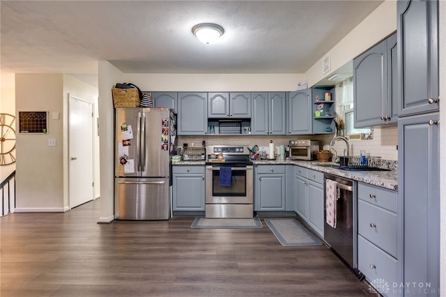 10452 S Union Rd, Miamisburg, OH 45342 - kitchen featuring appliances with stainless steel finishes, open shelves, gray cabinetry, dark wood finished floors, and tasteful backsplash