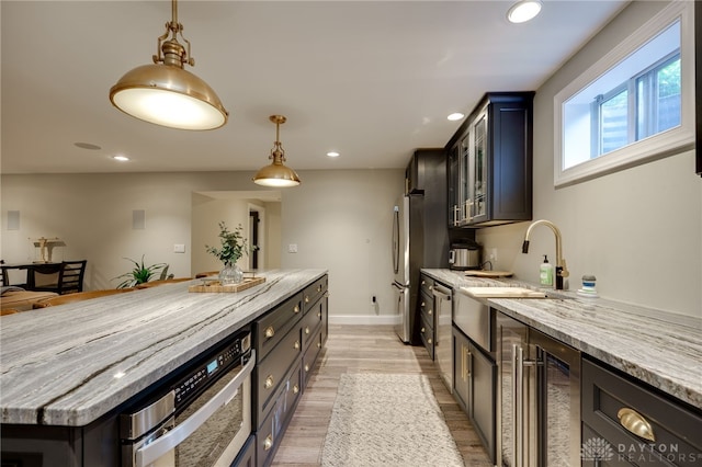 243 Woodside Trl, Clearcreek Twp, OH 45036 - kitchen with recessed lighting, light stone counters, light wood-style flooring, decorative light fixtures, and a center island