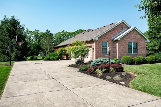 243 Woodside Trl, Clearcreek Twp, OH 45036 - view of side of home with brick siding, concrete driveway, a yard, and a garage