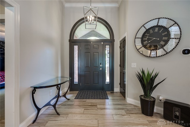 243 Woodside Trl, Clearcreek Twp, OH 45036 - entryway with a chandelier, light wood-style floors, ornamental molding, and a towering ceiling