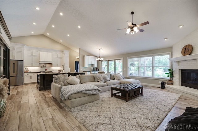 243 Woodside Trl, Clearcreek Twp, OH 45036 - living room with a ceiling fan, a brick fireplace, light wood-style floors, a chandelier, and high vaulted ceiling