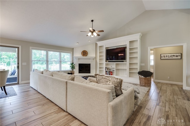 243 Woodside Trl, Clearcreek Twp, OH 45036 - living room featuring vaulted ceiling, light wood-style floors, a ceiling fan, healthy amount of natural light, and a brick fireplace