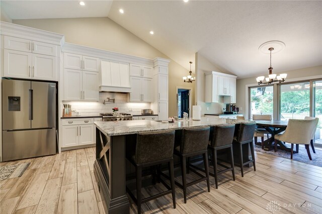 243 Woodside Trl, Clearcreek Twp, OH 45036 - kitchen with stainless steel fridge with ice dispenser, a chandelier, light wood finished floors, white cabinets, and custom exhaust hood