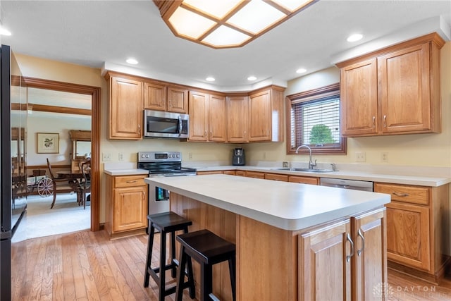 3875 Ferry Rd, Sugarcreek Twp, OH 45305 - kitchen with stainless steel appliances, light wood finished floors, light countertops, a kitchen island, and recessed lighting