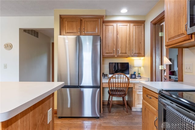 3875 Ferry Rd, Sugarcreek Twp, OH 45305 - kitchen featuring stainless steel appliances, light countertops, light wood-style flooring, recessed lighting, and brown cabinetry