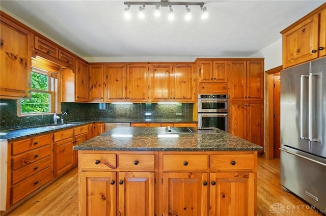 7255 State Route 48, Springboro, OH 45066 - kitchen with appliances with stainless steel finishes, light wood-style flooring, a kitchen island, and brown cabinetry