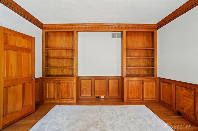 7255 State Route 48, Springboro, OH 45066 - unfurnished room featuring built in shelves, a wainscoted wall, ornamental molding, wood finished floors, and a decorative wall