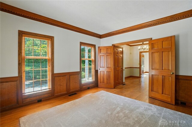7255 State Route 48, Springboro, OH 45066 - spare room with a chandelier, healthy amount of natural light, wood finished floors, wainscoting, and crown molding