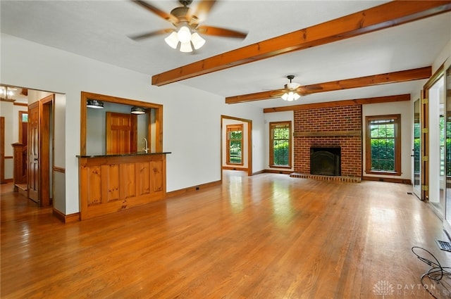 7255 State Route 48, Springboro, OH 45066 - unfurnished living room featuring wood finished floors, ceiling fan, beam ceiling, and a fireplace