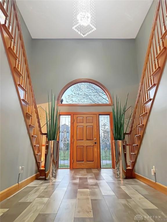 7171 Dominican Dr, Clayton, OH 45415 - entrance foyer with stairway, a chandelier, and a high ceiling
