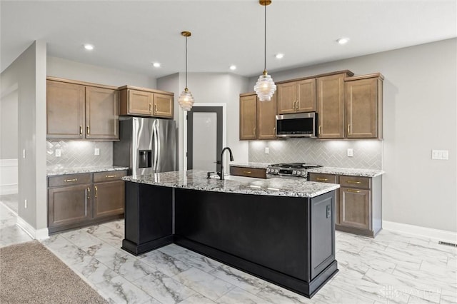 1796 Archerfield Pl, Miamisburg, OH 45342 - kitchen featuring appliances with stainless steel finishes, light marble finish flooring, tasteful backsplash, light stone countertops, and an island with sink