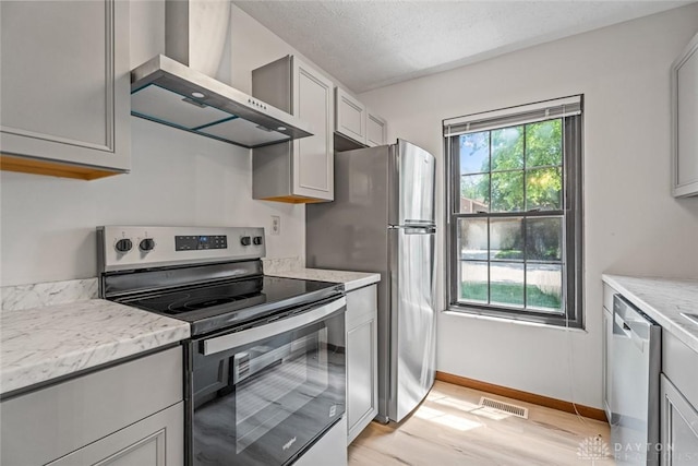 7607 Paragon Commons Cir, Dayton, OH 45459 - kitchen with stainless steel appliances, wall chimney range hood, light wood-type flooring, and gray cabinetry