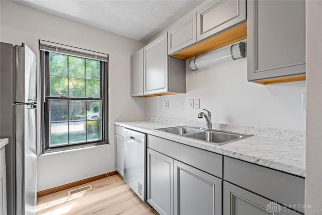 7607 Paragon Commons Cir, Dayton, OH 45459 - kitchen featuring stainless steel appliances, gray cabinets, light wood-style floors, and a textured ceiling