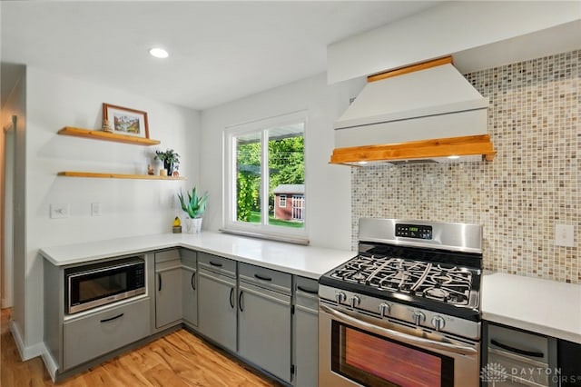320 Witherby Dr, Kettering, OH 45429 - kitchen with appliances with stainless steel finishes, premium range hood, gray cabinets, light wood finished floors, and tasteful backsplash