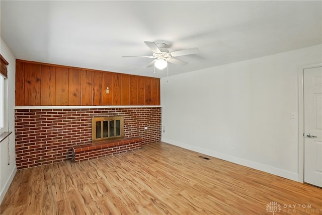 320 Witherby Dr, Kettering, OH 45429 - unfurnished living room featuring a ceiling fan, wood finished floors, a fireplace, and wooden walls