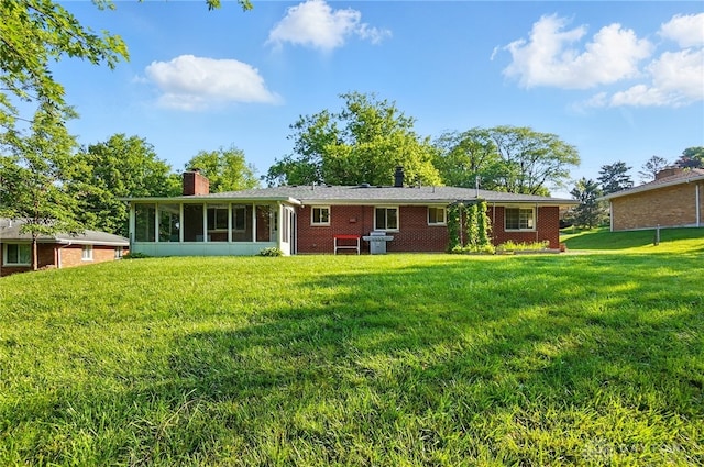 320 Witherby Dr, Kettering, OH 45429 - rear view of property featuring a chimney, a yard, a sunroom, and brick siding