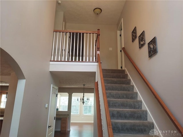 1052 Windpointe Way, Englewood, OH 45322 - stairs with arched walkways, a high ceiling, and a chandelier