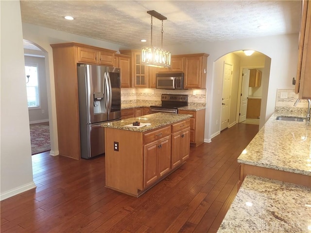 1052 Windpointe Way, Englewood, OH 45322 - kitchen with appliances with stainless steel finishes, arched walkways, light stone countertops, tasteful backsplash, and a textured ceiling