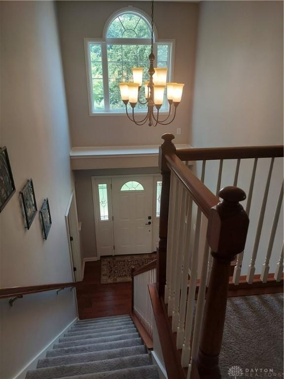 1052 Windpointe Way, Englewood, OH 45322 - stairs with a chandelier, carpet floors, and wood finished floors