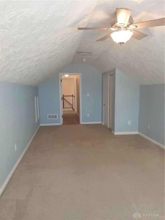 1052 Windpointe Way, Englewood, OH 45322 - bonus room with a textured ceiling, lofted ceiling, carpet, and a ceiling fan