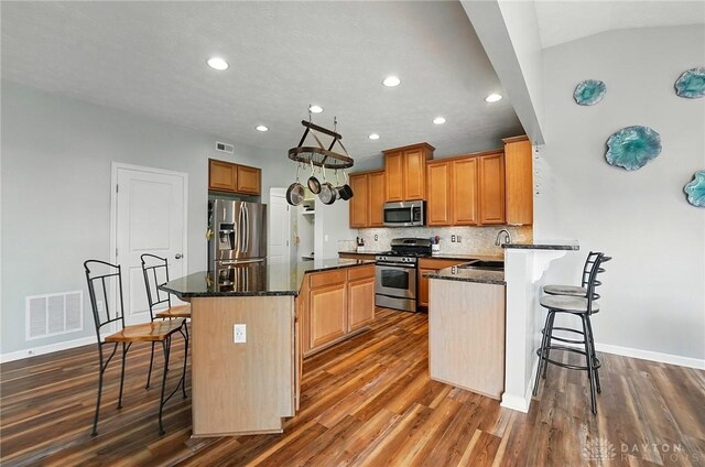 1662 S Branch Rd, Centerville, OH 45458 - kitchen with appliances with stainless steel finishes, a breakfast bar area, recessed lighting, dark wood-type flooring, and a center island