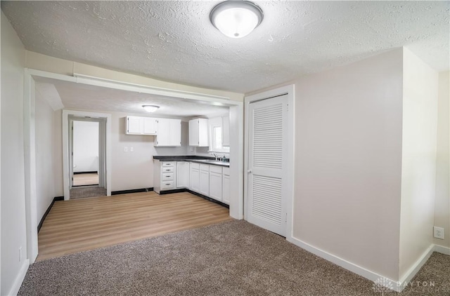 675 W Geiserman Rd, Piqua, OH 45356 - kitchen featuring dark countertops, white cabinetry, light colored carpet, and a textured ceiling