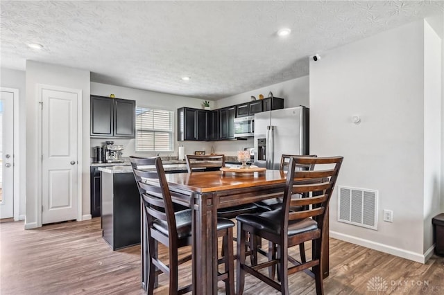 1918 Bessie Ave, Moraine, OH 45439 - dining space featuring light wood-style floors, a textured ceiling, and recessed lighting