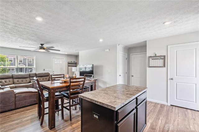 1918 Bessie Ave, Moraine, OH 45439 - kitchen featuring open floor plan, ceiling fan, light wood-type flooring, a center island, and a textured ceiling