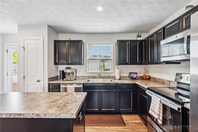 1918 Bessie Ave, Moraine, OH 45439 - kitchen with appliances with stainless steel finishes, light wood finished floors, light countertops, and dark cabinets