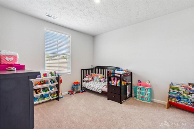 1918 Bessie Ave, Moraine, OH 45439 - carpeted bedroom featuring a textured ceiling and a crib